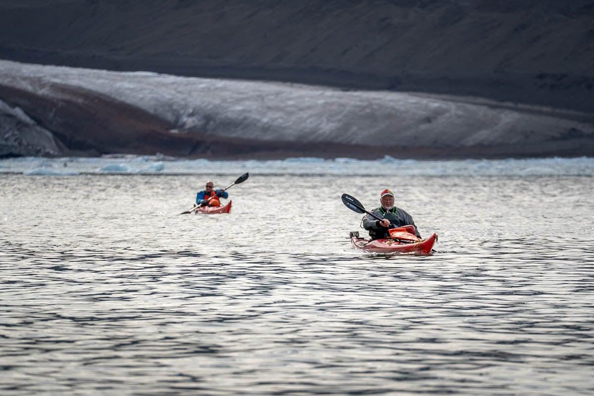 Kayakers paddling in front of glaciers in Svalbard, Norway