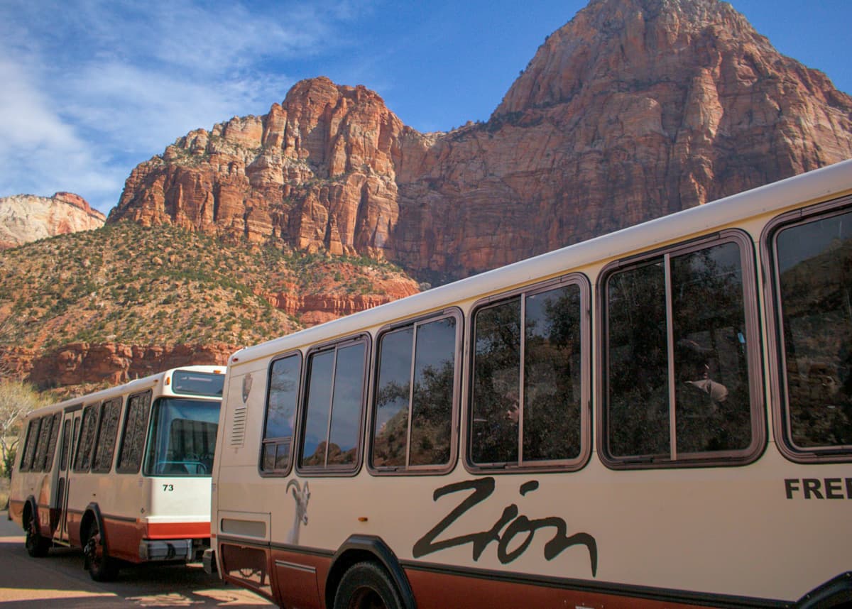 Zion shuttles with mountains in the background in Zion National Park
