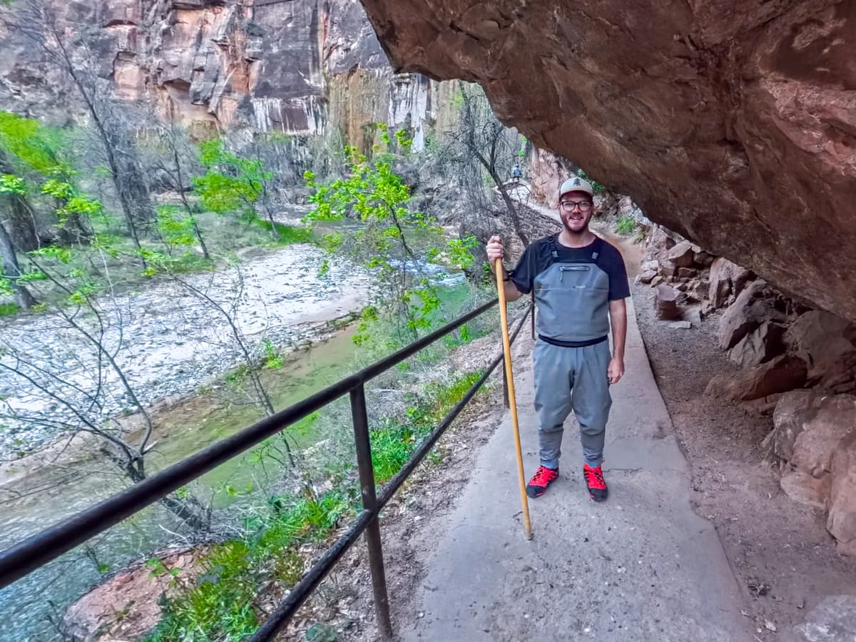 Smiling man standing along the Riverside Walk next to the Virgin River in Zion National Park