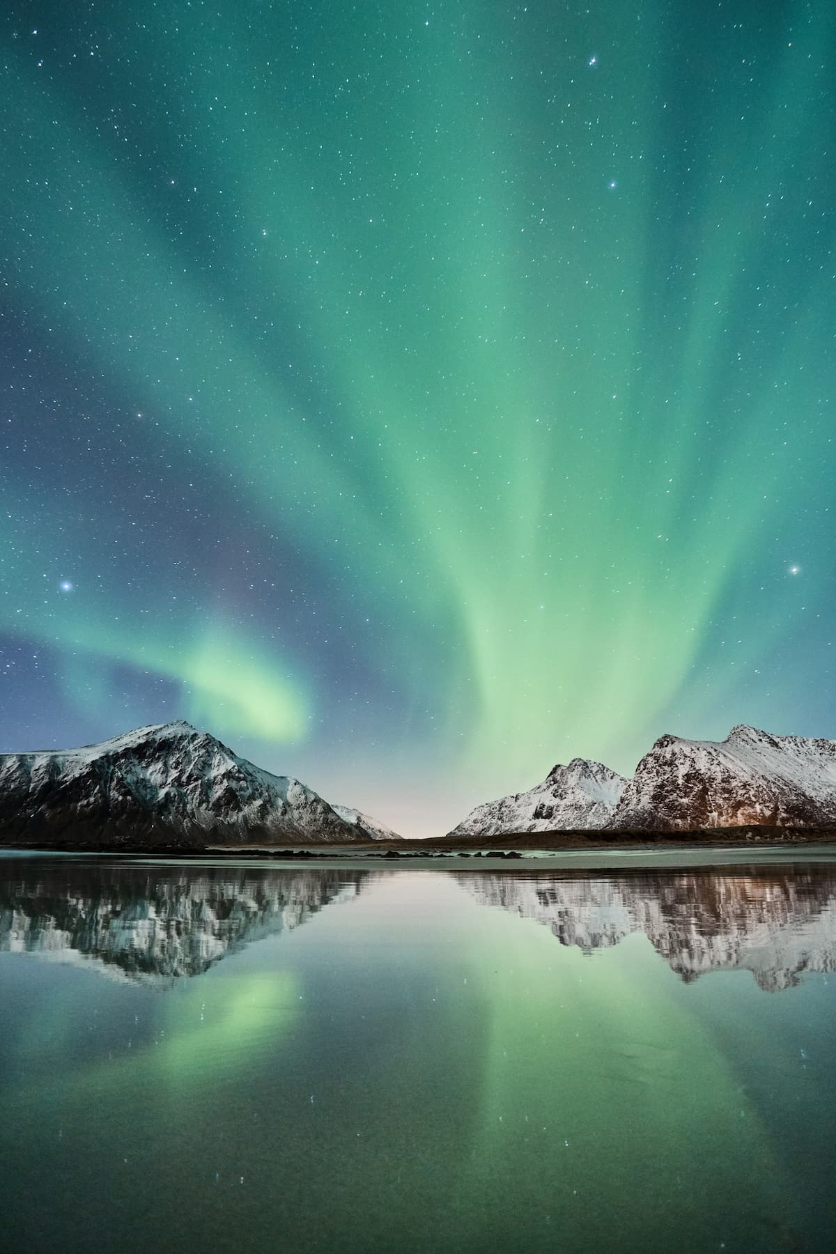 Northern Lights about snowy mountains in Norway