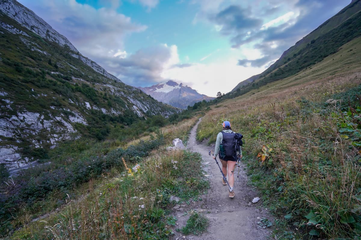 Woman hiking toward Vallée des Glaciers outside of Les Chapieux, France along the Tour du Mont Blanc