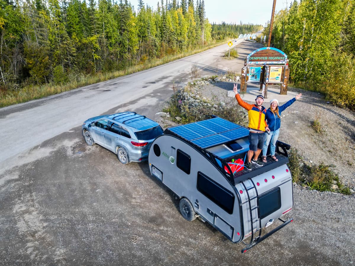 Couple standing on top of their Safari Condo Alto F1743 Expedition trailer along the Dempster Highway