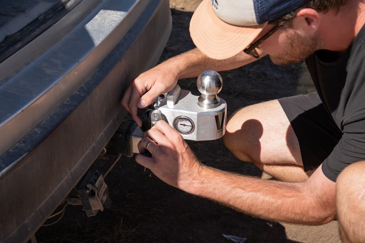Man inserting a Weigh Safe ball mount in a receiver tube on the back of a Toyota Highlander Hybrid SUV