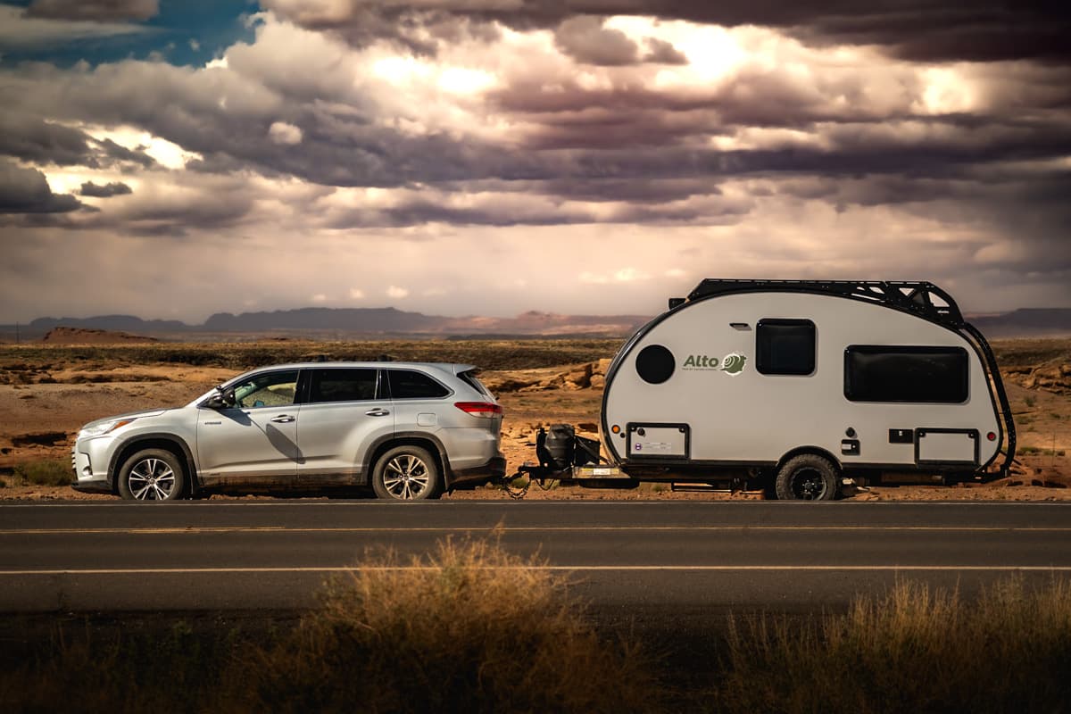 Toyota Highlander Hybrid SUV pulling a Safari Condo Alto F1743 Expedition with moody clouds in the background in the Grand Canyon
