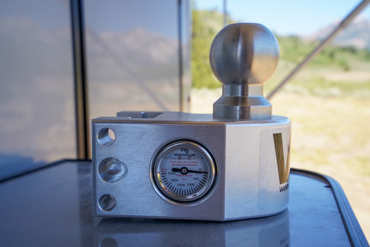 Ball mount with a built-in tongue scale sitting on a table of a Safari Condo Alto A1752 trailer