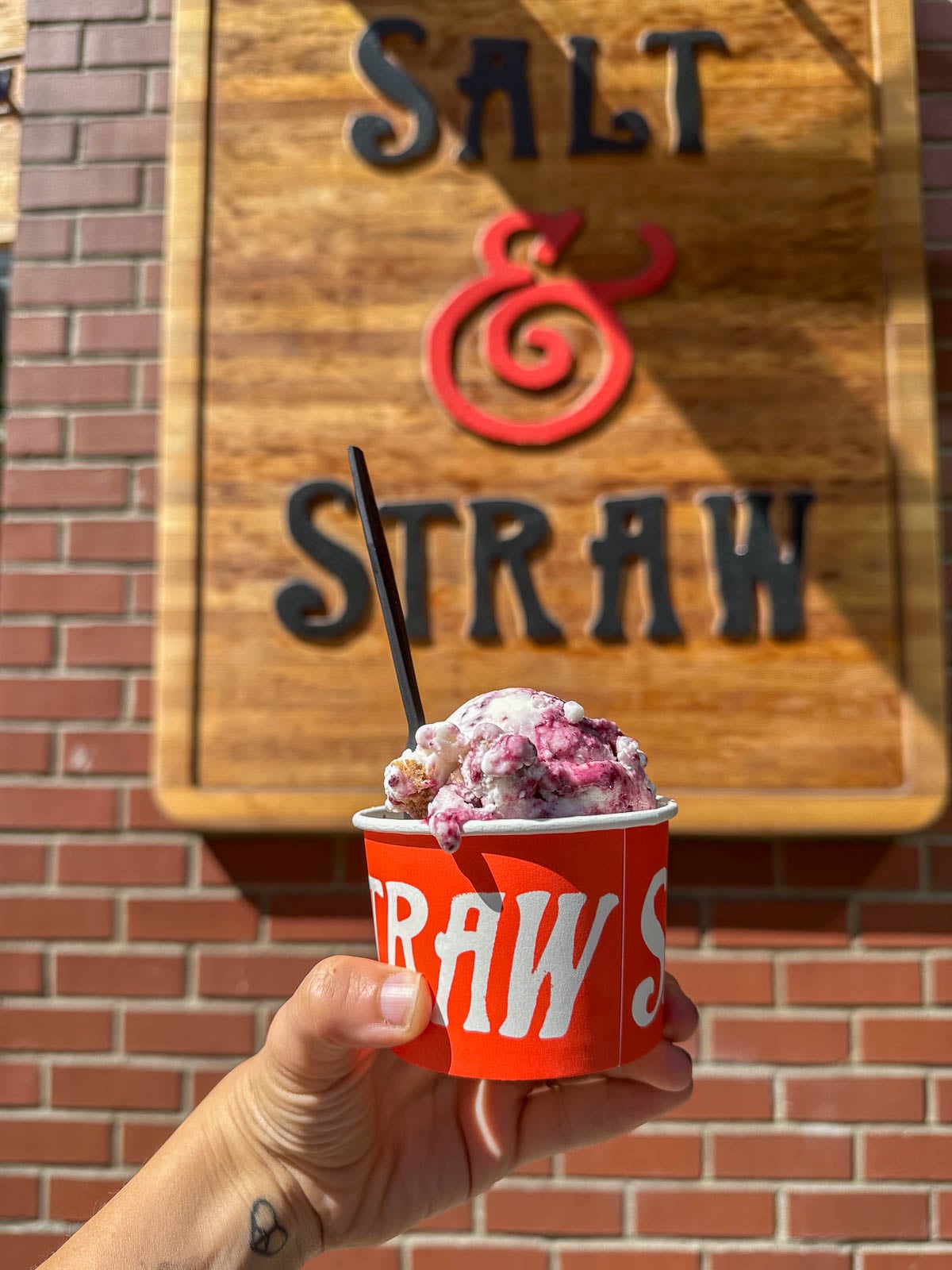 Cup of ice cream in front of Salt and Straw sign in Seattle, Washington